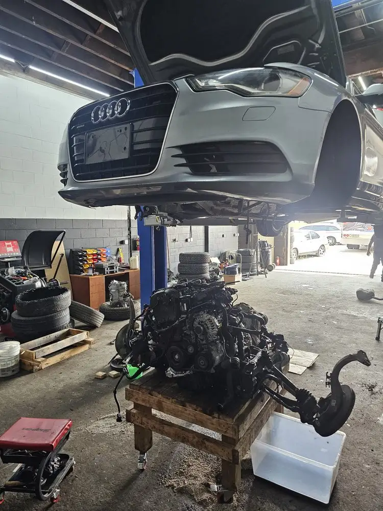 Audi sedan raised on a lift over a removed engine